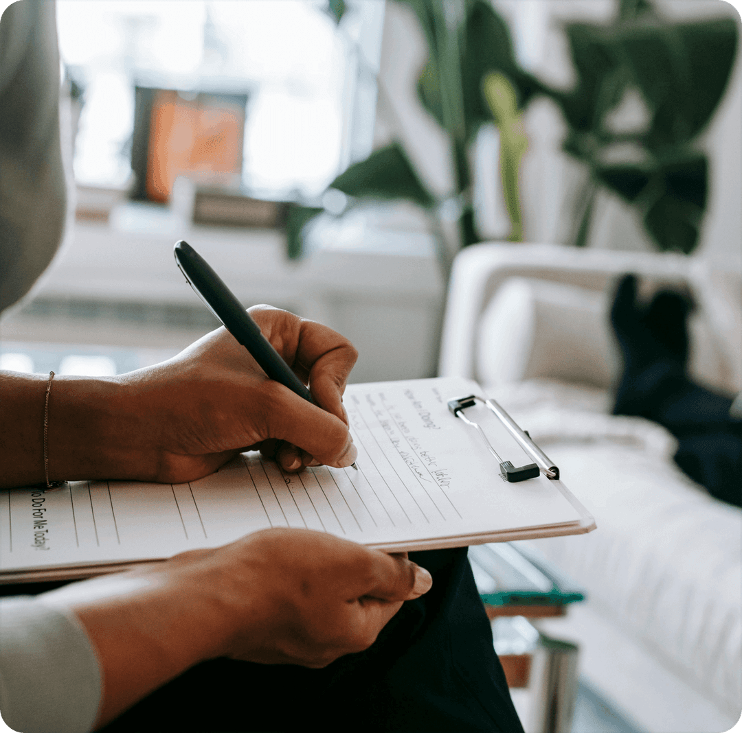 Hands writing on a clipboard